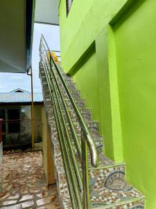 eine Treppe neben einem grünen Gebäude in der Unterkunft JJL pension house in Siquijor