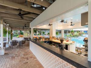 un restaurant avec un bar offrant une vue sur l'eau dans l'établissement Novotel Cairns Oasis Resort, à Cairns