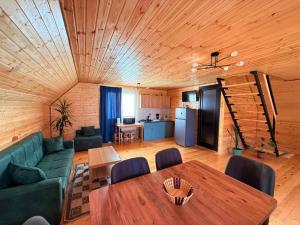 a living room with a table and a kitchen at Shelva Cottage kazbegi in P'khelshe