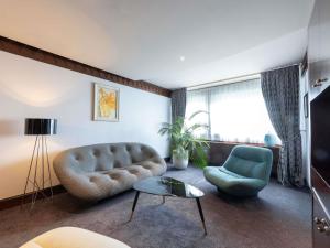 a living room with a couch and a chair at Sofitel Lyon Bellecour in Lyon