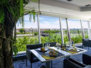 a dining room with a table and a large window at Sofitel Lyon Bellecour in Lyon