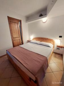 a bedroom with a wooden bed with a wooden door at Lo chalet di Lucky in Campodolcino