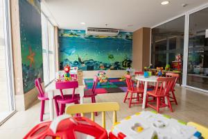 a restaurant with tables and chairs and a play room at Gran Mareiro Hotel in Fortaleza