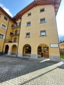 a large yellow building with a sign on it at Lo chalet di Lucky in Campodolcino