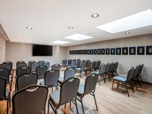 a room with rows of chairs and a flat screen tv at Sofitel Bogota Victoria Regia in Bogotá
