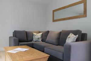 a living room with a couch and a table at Honeysuckle Cottage with Hot Tub Park Facilities in Milford on Sea