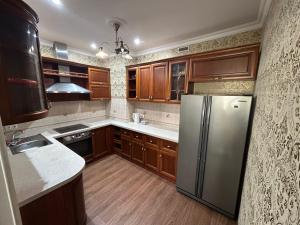 a kitchen with wooden cabinets and a stainless steel refrigerator at 15-69 Oasis-3 kom in Aktau