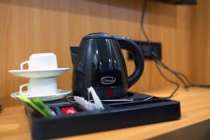 a black tea kettle sitting on top of a table at Golden GSC Hotel in Amritsar