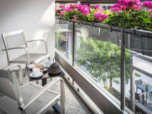 a balcony with a table and chairs and flowers at Sofitel Strasbourg Grande Ile in Strasbourg +216 photos