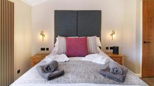 Un dormitorio con una cama grande con toallas. en The Shrubbery Treehouse Park Facilities, en Milford on Sea