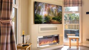 Una sala de estar con chimenea y TV de pantalla plana. en The Shrubbery Treehouse Park Facilities, en Milford on Sea 6 fotos más
