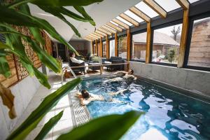 a swimming pool with two people in it at Logis Hôtel Au Gai Soleil du Mont-Aiguille in Chichilianne