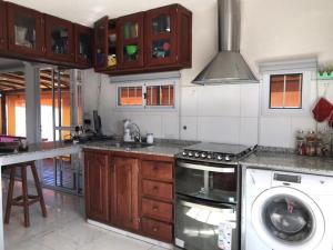 a kitchen with a stove and a dishwasher at casa con vista 360 a las montañas y pileta in Tanti