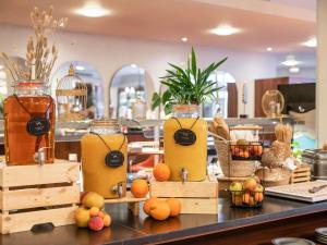a counter with jars of juice and fruits on it at Mercure Paris CDG Airport & Convention in Roissy-en-France