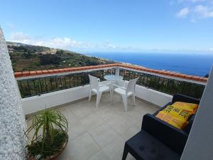 a balcony with a table and chairs and the ocean at INN Mountain Country House in Caniço