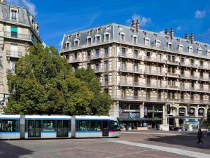 a tram in front of a tall building at ibis Grenoble Centre Bastille in Grenoble