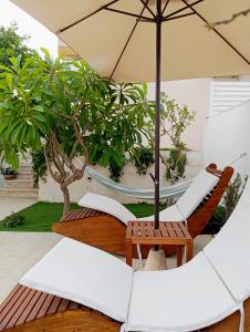 a patio with two chairs and an umbrella at Casa Vacanze" Almarè" in Marina di Modica