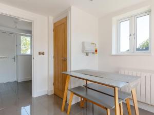 una cucina bianca con un tavolo e una finestra di Blackberry Cottage a Stowmarket