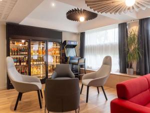 una sala de espera con sillas y un bar en ibis Lyon Est Bron, en Bron