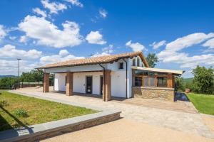 a small white house with a roof at Villa Setona by VacaVilla in Bucine
