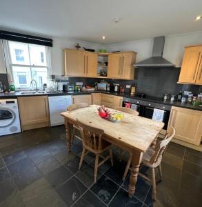 a kitchen with a wooden table with a bowl of fruit on it at Luxury Room - St Leonards on Sea - East Sussex in Hollington +12 photos