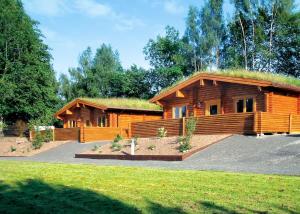 Coupar AngusにあるBeech Hedgeの草屋根の大きなログキャビン