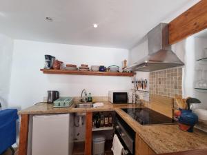 a kitchen with a sink and a stove top oven at Casa Romero in Cortes de la Frontera +10 photos