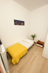 a white room with a bed with a yellow blanket at Borgo nel Vigneto 1 in Erbusco +3 photos