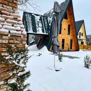 a house is covered in snow with a building at Challet in Cheia