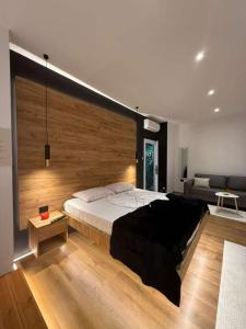 a bedroom with a large bed and a couch at You & Me Suite in Shkodër