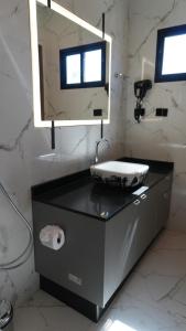 a bathroom with a sink and a mirror at Loft Jeri Premium in Jericoacoara +11 photos