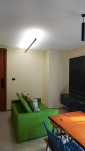 a living room with a green couch and a television at Loft Jeri Premium in Jericoacoara