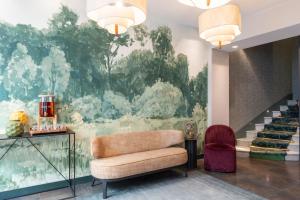 Un vestíbulo con un sofá y un gran cuadro en la pared. en Hôtel Brittany, en París
