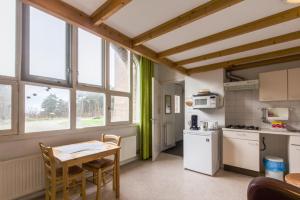 a kitchen with a table and a small table and chairs at Landgoed Huize Glory in Bergen aan Zee