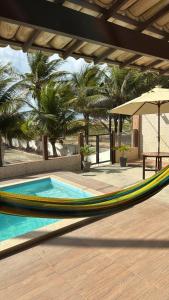 eine Hängematte vor einem Pool mit Palmen in der Unterkunft Casa de Praia - Aracaju - Jatobá in Barra dos Coqueiros + 49 Fotos