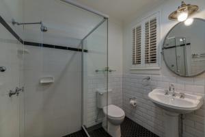 y baño con aseo, lavabo y espejo. en Edward Lodge New Fam, en Brisbane