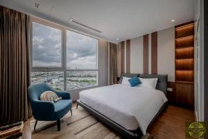 Un dormitorio con una cama y una silla y una ventana. en Landmark 81 Imperial Tower Hotel & Skyline Lounge in Ho Chi Minh City, en Ho Chi Minh