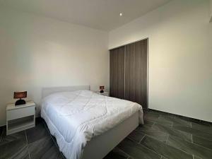 ein Schlafzimmer mit einem weißen Bett, einem Nachttisch und einem Bett der Marke sidx sidx sidx. in der Unterkunft Maison neuve proche plage, 3 chambres, 6 couchages à Saint-Denis d'Oléron - FR-1-246A-374 in La Michelière