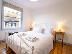 a bedroom with a white bed with towels on it at Easter Cottage - Central Rye Effortless Chic Pass the Keys in Rye