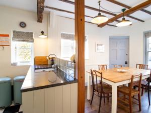 a kitchen and dining room with a wooden table at Easter Cottage - Central Rye Effortless Chic Pass the Keys in Rye