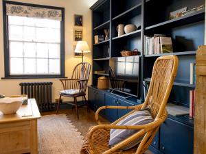 a room with two chairs and a blue book shelf at Easter Cottage - Central Rye Effortless Chic Pass the Keys in Rye