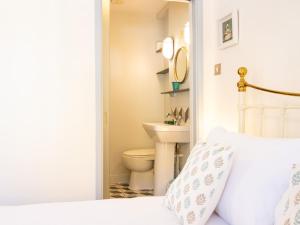 a white bedroom with a toilet and a bed at Easter Cottage - Central Rye Effortless Chic Pass the Keys in Rye +31 photos