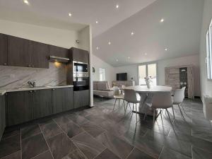 eine Küche und ein Esszimmer mit Tisch und Stühlen in der Unterkunft Maison neuve 3 chambres à 2 pas de la plage - FR-1-246A-377 in La Michelière