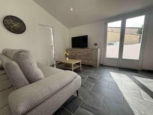 ein Wohnzimmer mit Sofa und Fernseher in der Unterkunft Maison neuve 3 chambres à 2 pas de la plage - FR-1-246A-377 in La Michelière