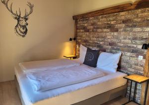 a bed in a room with a brick wall at Pension Leano in Nötsch