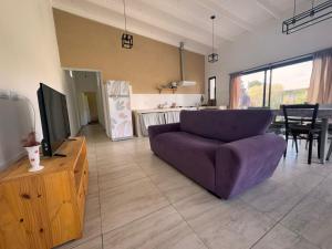 a living room with a purple couch and a kitchen at El Renacer Duggan in Duggan