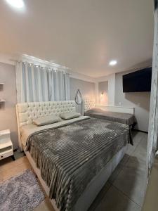 a bedroom with two beds and a flat screen tv at STUDIO 201 | WIFI 600MB | RESIDENCIAL JC, um lugar para ficar. in Belém Novo +27 photos