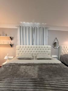 a white bedroom with a large bed and a window at STUDIO 201 | WIFI 600MB | RESIDENCIAL JC, um lugar para ficar. in Belém Novo