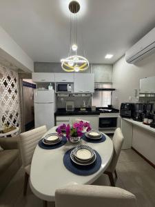 a kitchen with a white table and chairs in a kitchen at STUDIO 201 | WIFI 600MB | RESIDENCIAL JC, um lugar para ficar. in Belém Novo