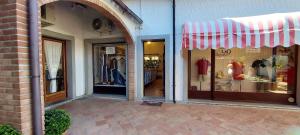 a store with a red and white striped awning in front of a building at Sarzana- Mobilhome 5 persone Pool and Garden in Sarzana